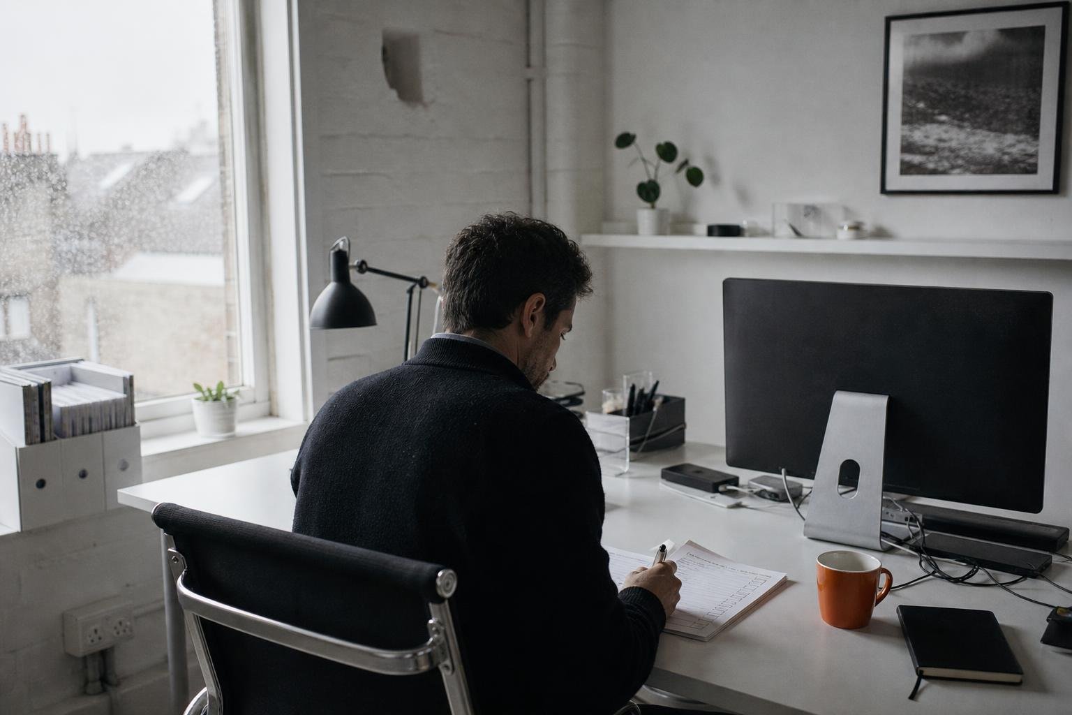 One account manager working alone through a paper checklist at a desk, the weekly check behind a paid ads account.