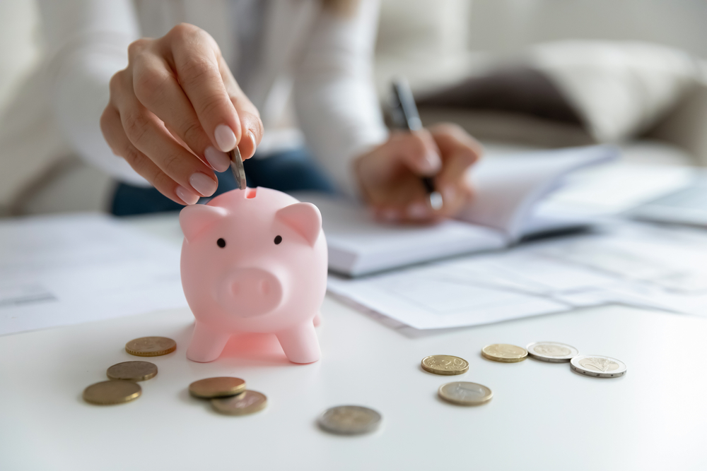 A coin being dropped into a piggy bank