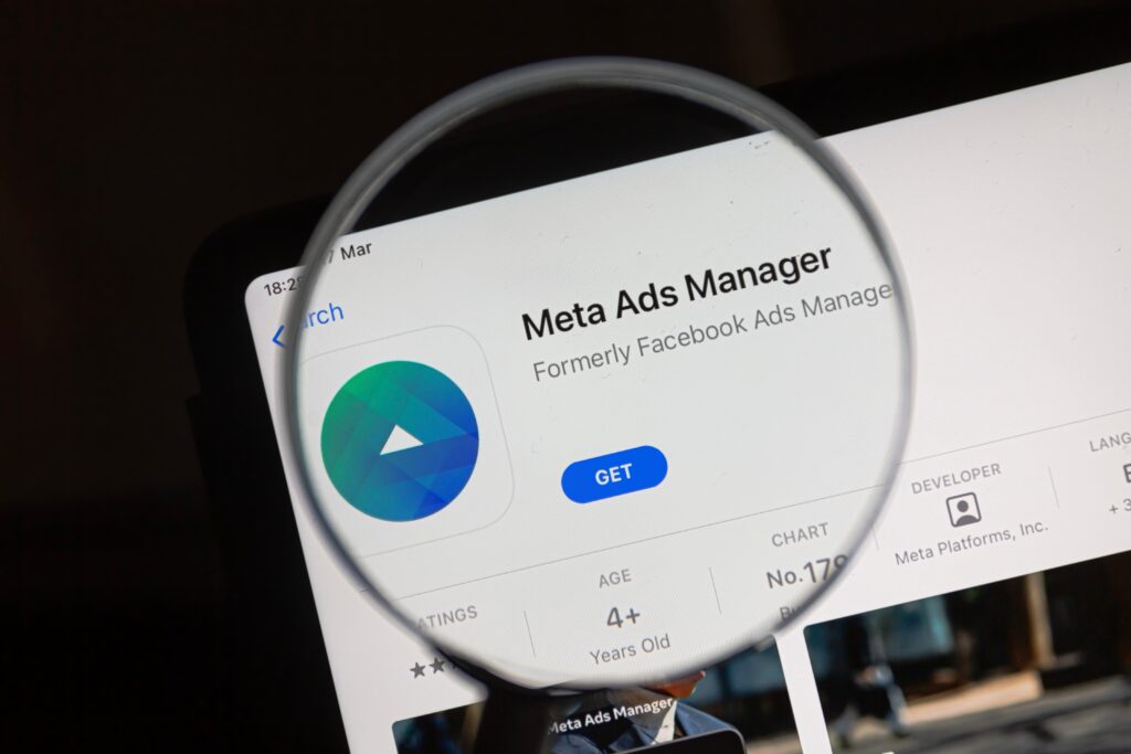 A magnifying glass held over the words "Meta Ads Manager"